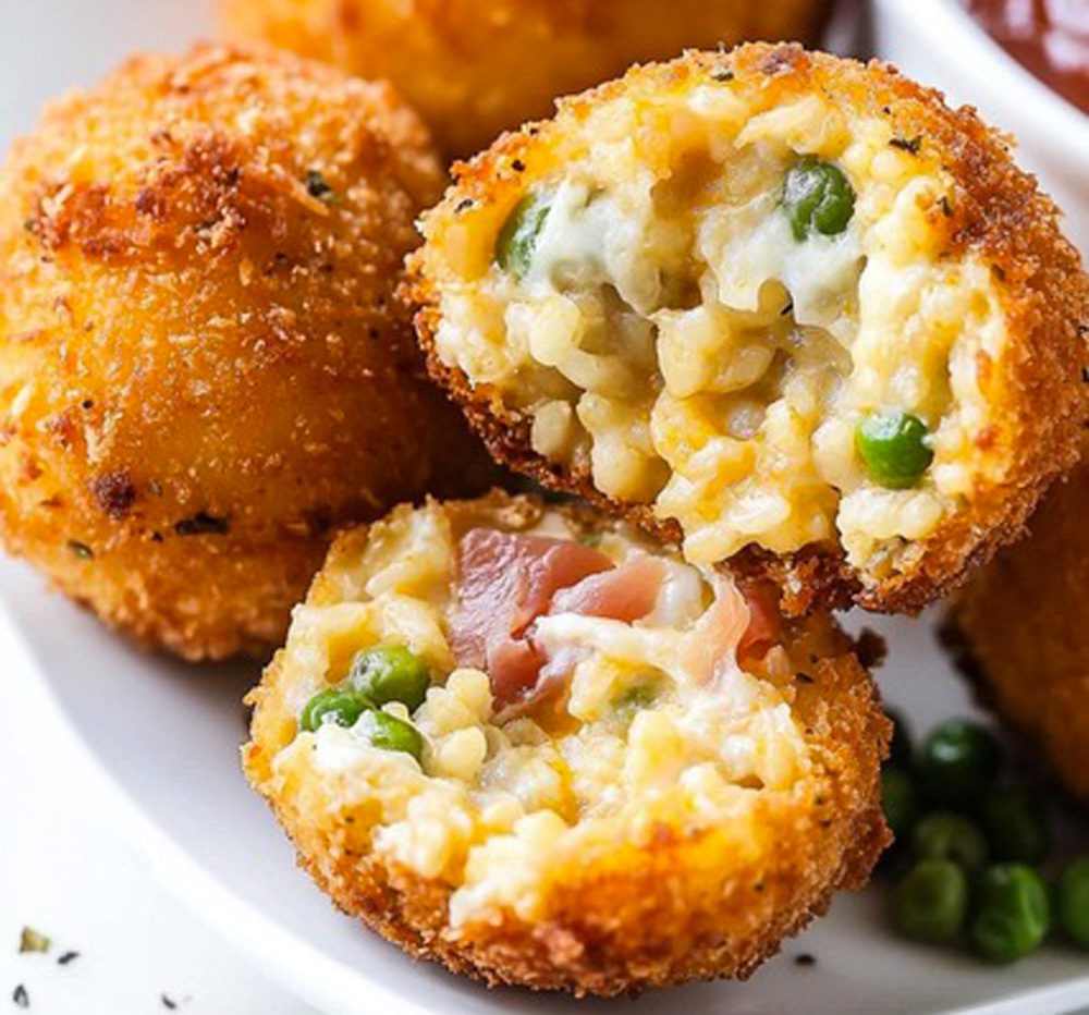 Arancini di riso con prosciutto, piselli e mozzarella