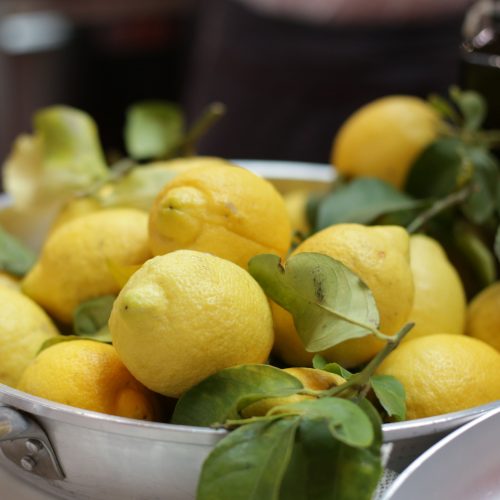 Bere acqua e limone al mattino fa bene o fa male? In foto, una pentola piena di limoni freschi