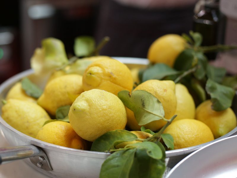 Bere acqua e limone al mattino fa bene o fa male? In foto, una pentola piena di limoni freschi