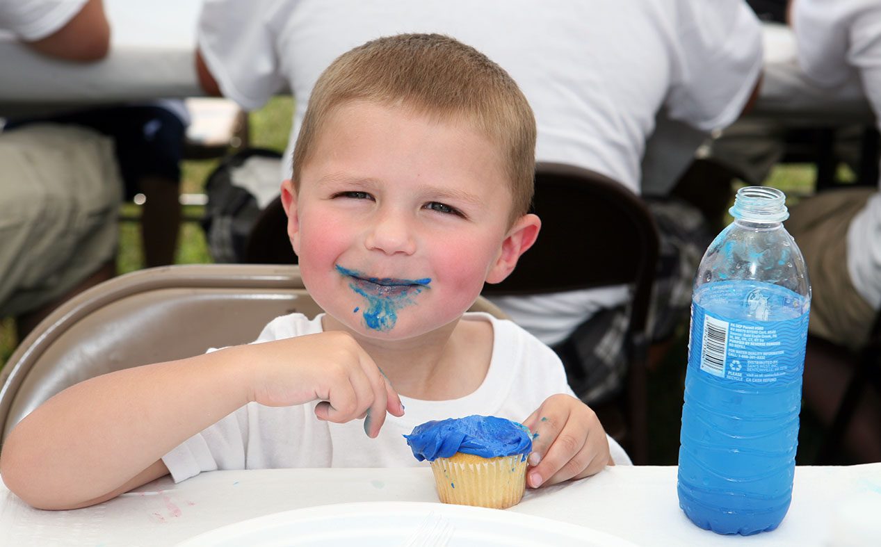 sovrappeso, bambino che mangia un dolce colorato